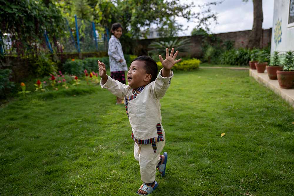 A smiling Asher runs around in the shelter at the garden